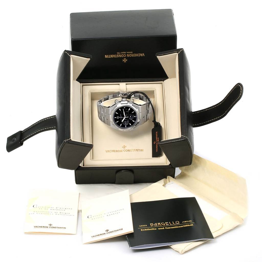 The Vacheron Constantin Overseas 49150.B01A.9097 Men's Stainless Steel Black Dial 49150.B01A.9097 Men's Stainless Steel Black Dial watch is displayed inside its box, along with manuals and a certificate, viewed from above.