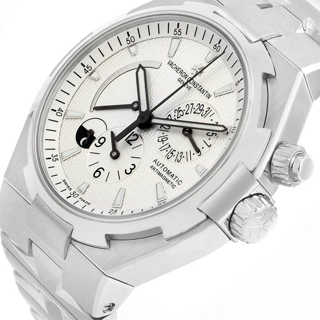 The image shows a Vacheron Constantin Overseas 47450/B01A-9226 Men's Stainless Steel Silver Dial 47450/B01A-9226 Men's Stainless Steel Silver Dial watch at an angled close-up, highlighting its dial, crown, and partial bracelet.