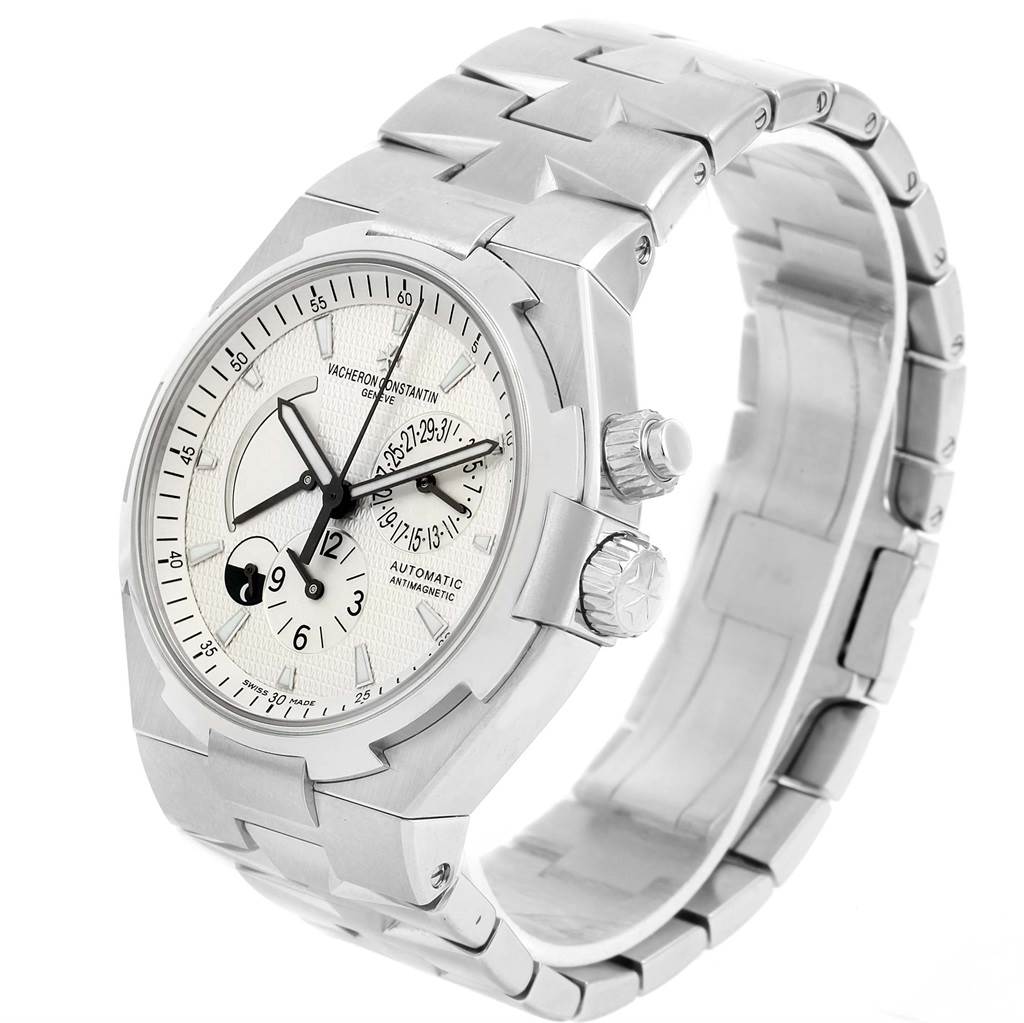 The image shows a Vacheron Constantin Overseas 47450/B01A-9226 Men's Stainless Steel Silver Dial 47450/B01A-9226 Men's Stainless Steel Silver Dial model watch at a three-quarter angle, highlighting the face, bezel, and stainless steel bracelet.