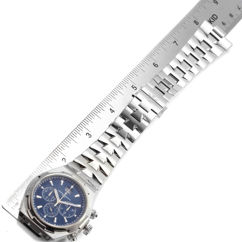 The image shows a Vacheron Constantin Overseas 49150.B01A.9745 Men's Stainless Steel Blue Dial 49150.B01A.9745 Men's Stainless Steel Blue Dial watch laid flat with a ruler for scale, highlighting the face, bezel, and bracelet.