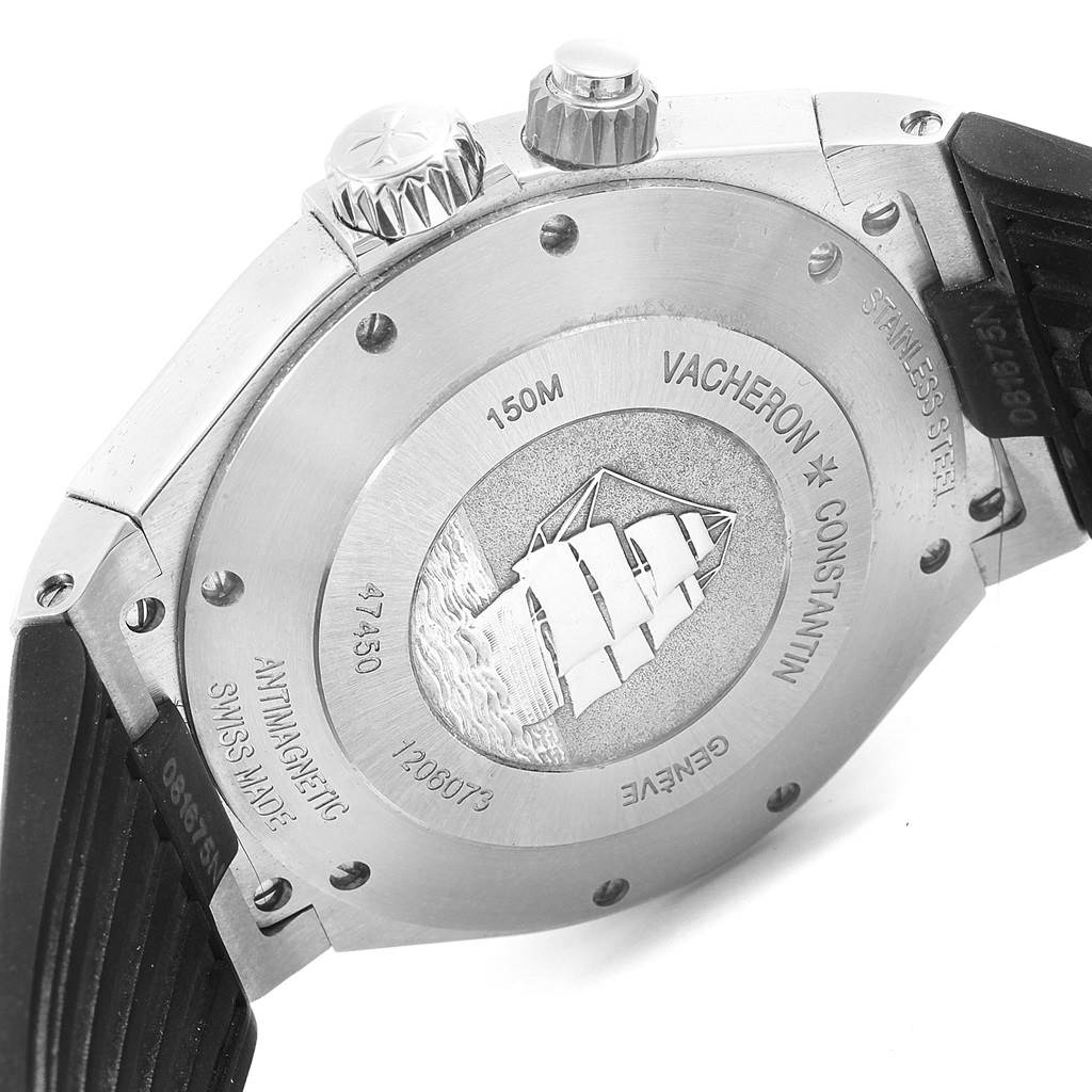 The image shows the back case and crown of a Vacheron Constantin Overseas 47450/000W-9511 Men's Stainless Steel Grey Dial 47450/000W-9511 Men's Stainless Steel Grey Dial watch, including its inscriptions and decorative ship motif.