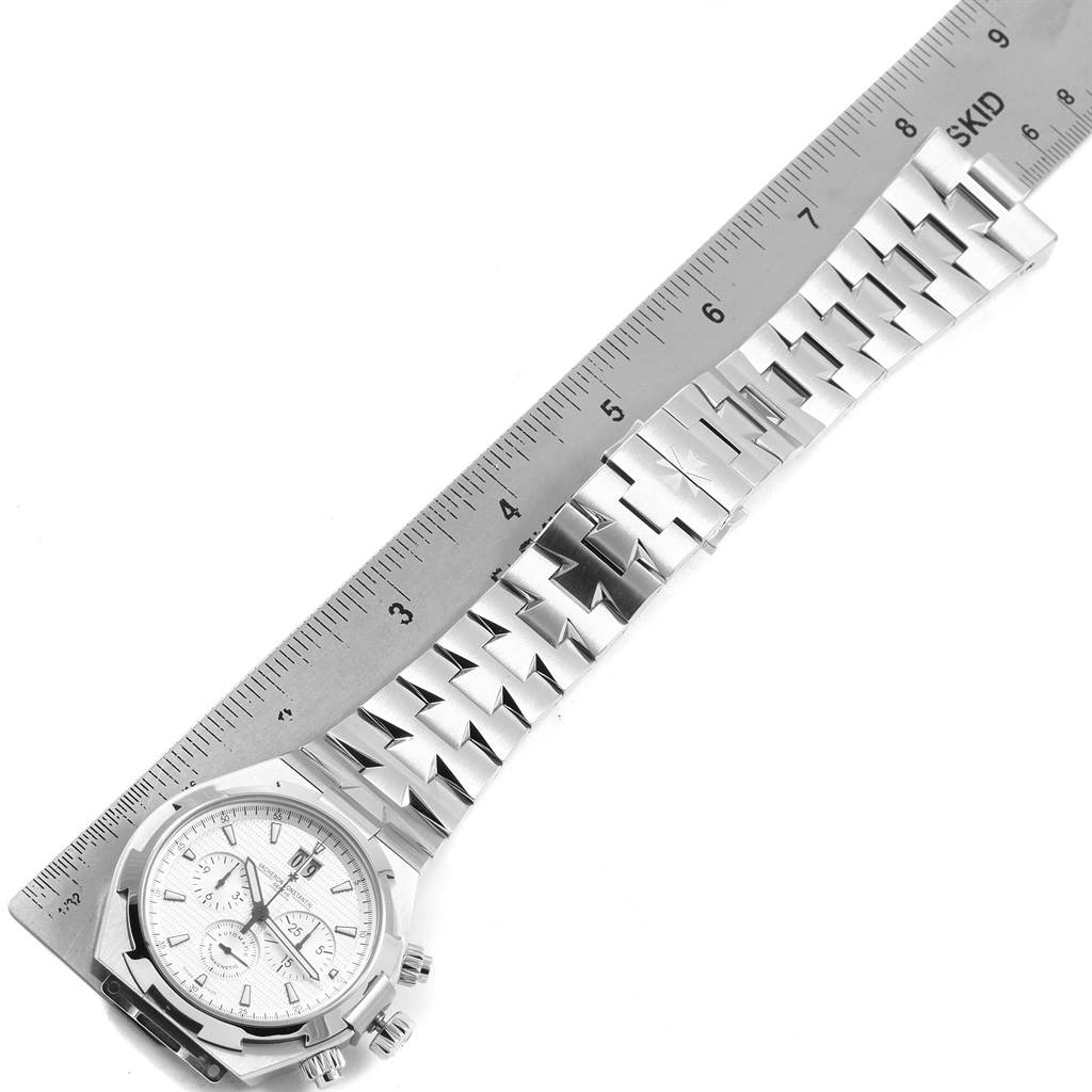 The image shows a Vacheron Constantin Overseas Men's Stainless Steel Silver Dial Men's Stainless Steel Silver Dial watch featuring the face and bracelet, positioned alongside a ruler for scale.