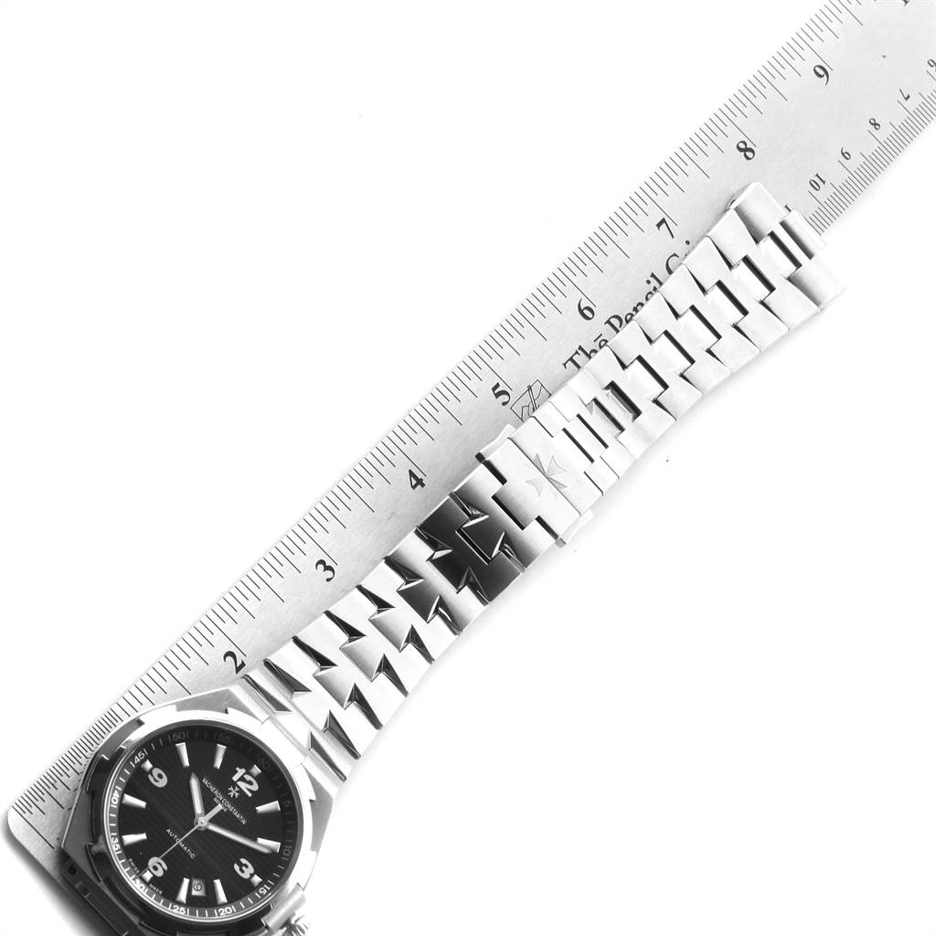 The image shows a Vacheron Constantin Overseas 47040/B01A-9094 Men's Stainless Steel Black Dial 47040/B01A-9094 Men's Stainless Steel Black Dial watch and its bracelet laid out next to a ruler for measurement.