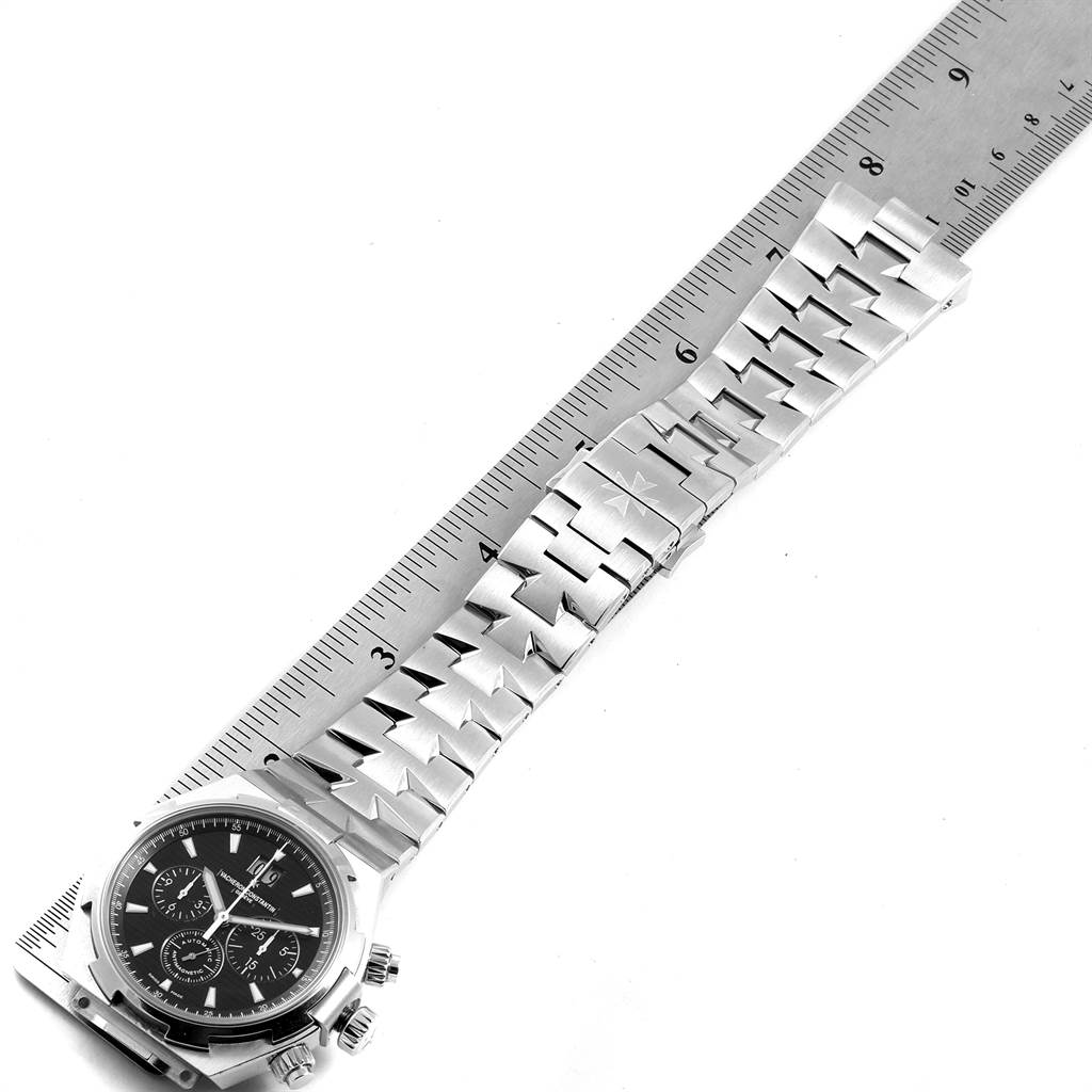 The image shows a Vacheron Constantin Overseas 49150.B01A.9097 Men's Stainless Steel Black Dial 49150.B01A.9097 Men's Stainless Steel Black Dial watch and bracelet laid flat beside a ruler for measurement.