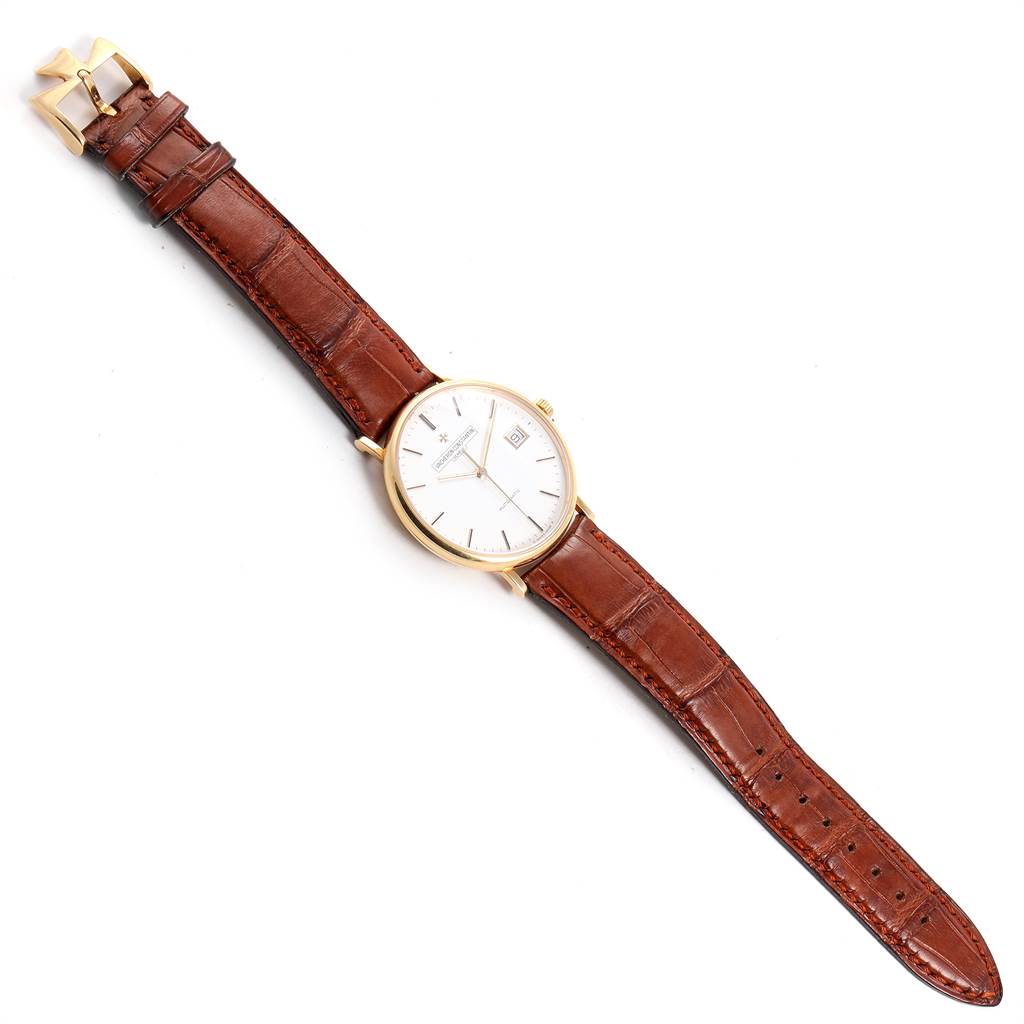 The image shows a Vacheron Constantin Patrimony 42002 Men
s Yellow Gold White Dial 42002 Men
s Yellow Gold White Dial watch laid flat, featuring a brown leather strap and a gold case with a white dial.