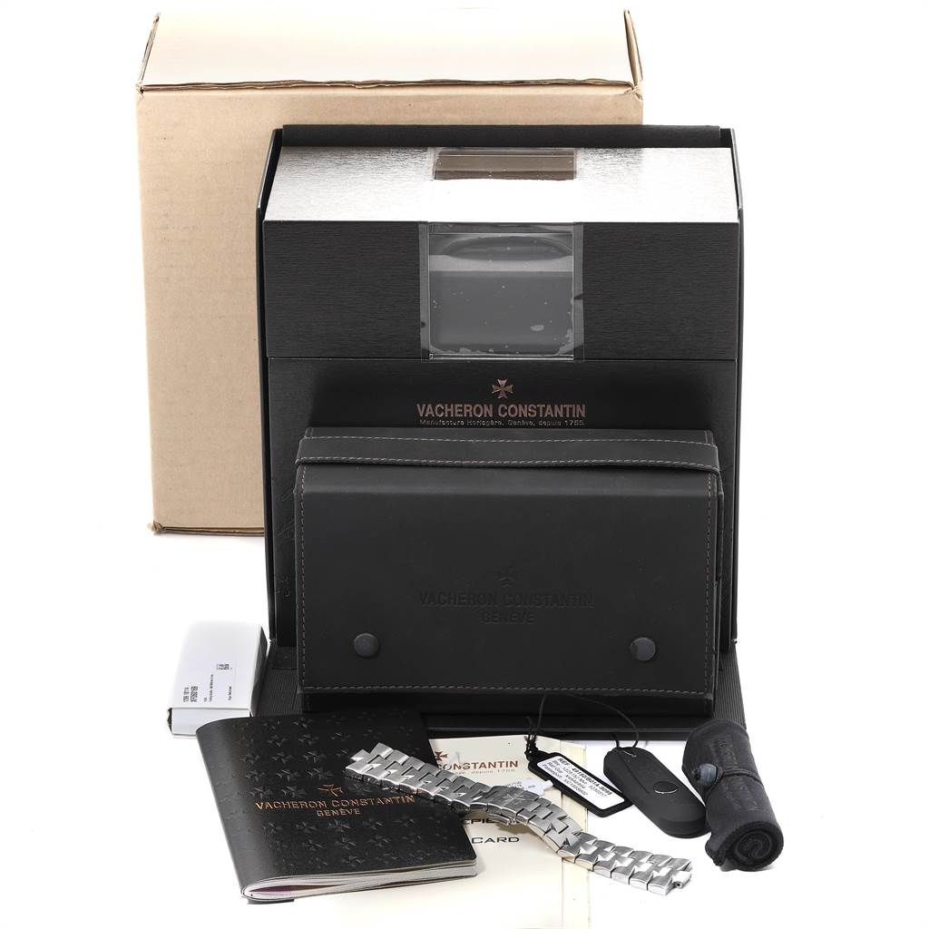 The image shows a Vacheron Constantin Overseas 49150/B01A-9095 Men
s Stainless Steel Silver Dial 49150/B01A-9095 Men
s Stainless Steel Silver Dial watch box, documents, extra links, a leather case, and additional accessories from a frontal angle.