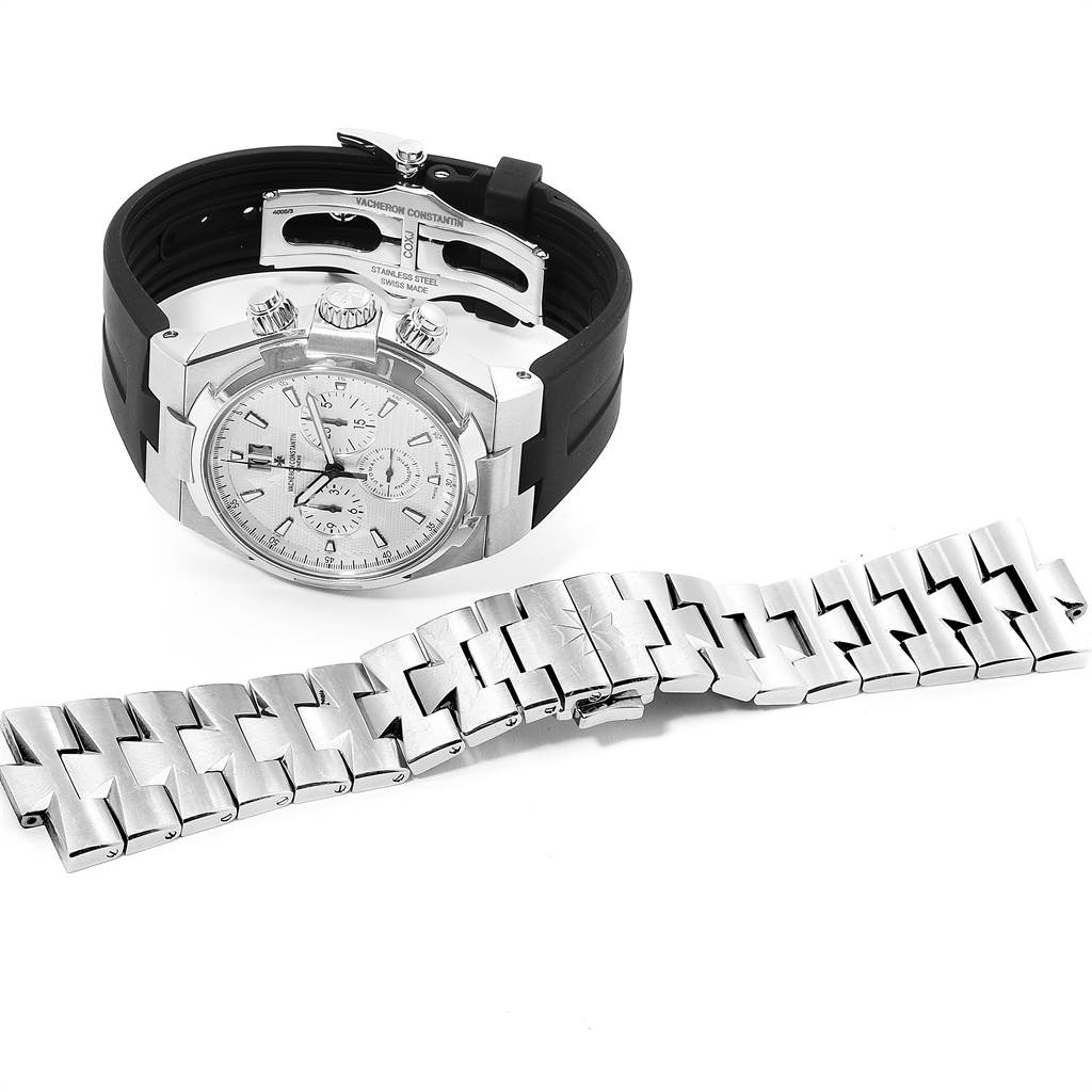 The image shows a Vacheron Constantin Overseas 49150/B01A-9095 Men
s Stainless Steel Silver Dial 49150/B01A-9095 Men
s Stainless Steel Silver Dial watch with a black strap and a separate metal bracelet lying flat in front of it.