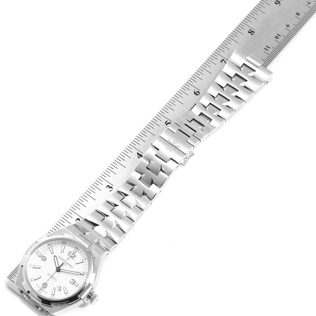 The Vacheron Constantin Overseas 47040B01A-9093 Men's Stainless Steel Silver Dial 47040B01A-9093 Men's Stainless Steel Silver Dial watch is shown from an overhead angle next to a ruler, displaying the watch face and metal bracelet.