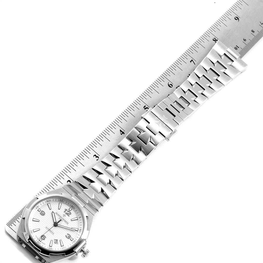 The Vacheron Constantin Overseas 47040B01A-9093 Men's Stainless Steel Silver Dial 47040B01A-9093 Men's Stainless Steel Silver Dial watch is shown laying flat with its bracelet being measured against a ruler.