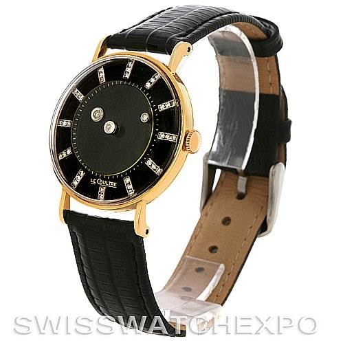 This image shows a side-angle view of a Vintage Jaeger LeCoultre watch, highlighting the gold case, black dial, and leather strap.
