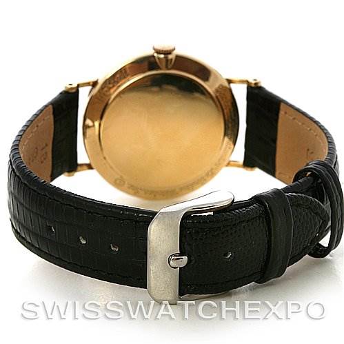 This image showcases the back view of a Vintage Jaeger LeCoultre watch featuring a gold case and black leather strap.