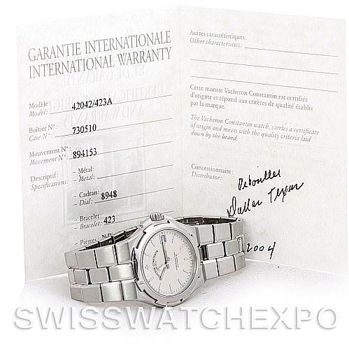 The image shows a Vacheron Constantin Overseas 42042 Men's Stainless Steel Silver Dial 42042 Men's Stainless Steel Silver Dial model watch placed in front of its international warranty documentation.