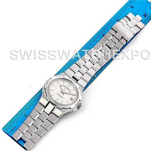 The Vacheron Constantin Overseas 42042 Men's Stainless Steel Silver Dial 42042 Men's Stainless Steel Silver Dial watch is shown, laid flat with its face up, next to a blue measuring tool.