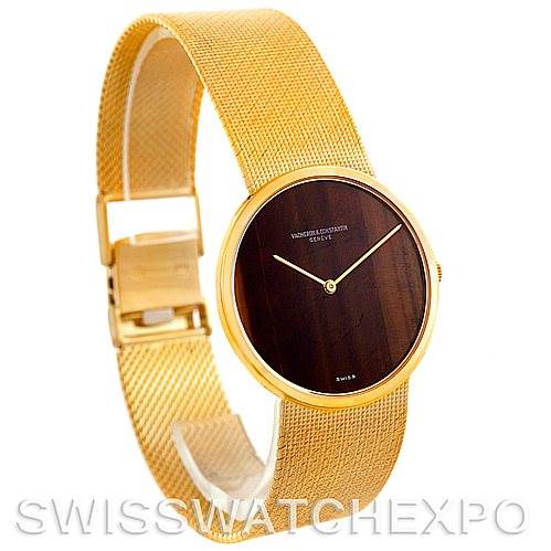 The image shows a side view of a vintage Vacheron Constantin watch with a gold mesh band and a dark dial.
