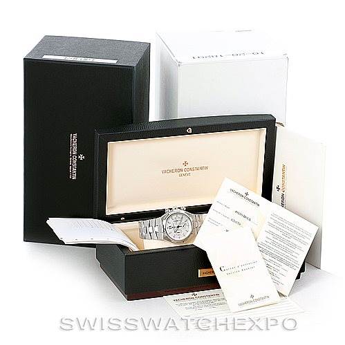 The image shows a Vacheron Constantin Overseas 49150 Men
s Stainless Steel Silver Dial 49150 Men
s Stainless Steel Silver Dial watch in its open box with accompanying booklets and packaging.