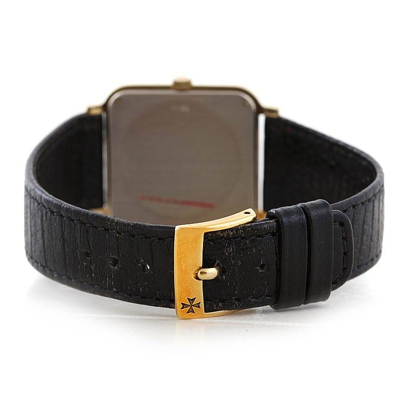 The image shows the back view of a Vintage Vacheron Constantin watch with a gold buckle and black leather strap.