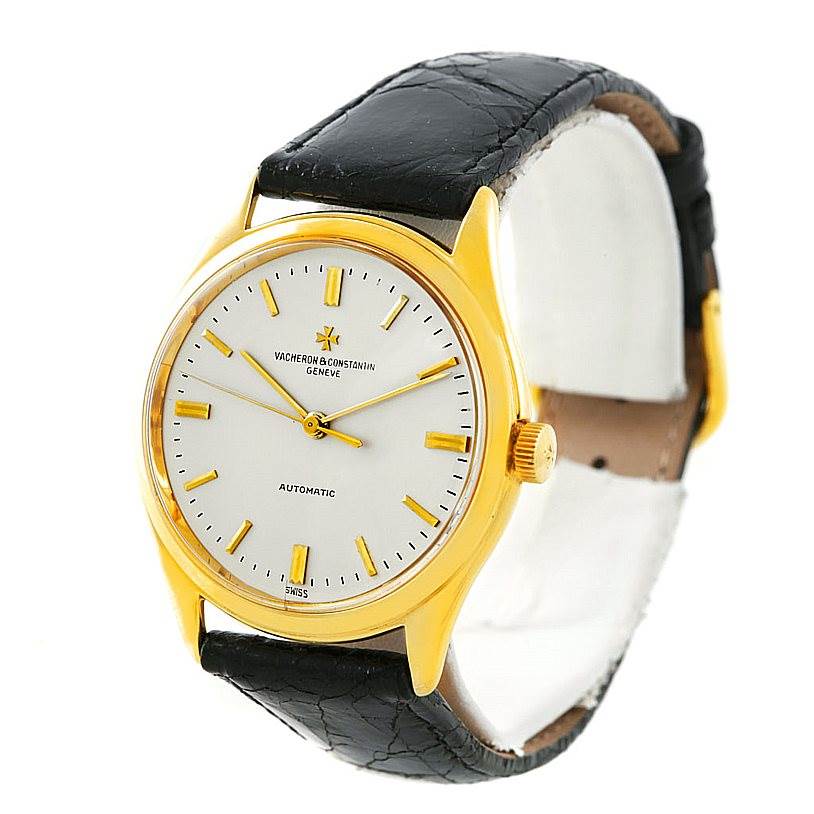 This image shows a Vacheron Constantin Vintage 4870 Men's Yellow Gold Silver Dial 4870 Men's Yellow Gold Silver Dial watch at an angle highlighting its gold case, white dial, and black leather strap.