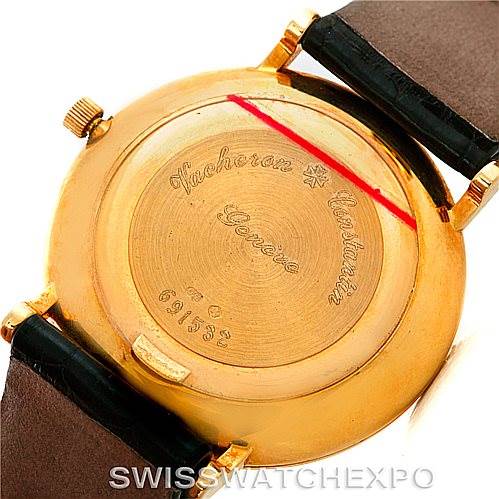 This image shows the case back of the Vintage Vacheron Constantin watch, featuring inscriptions and attached leather straps.