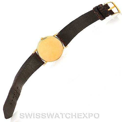 This image shows a Vacheron Constantin Vintage 33076 Men's Yellow Gold Beige Dial 33076 Men's Yellow Gold Beige Dial watch from an overhead angle, featuring a gold case and a black leather strap.