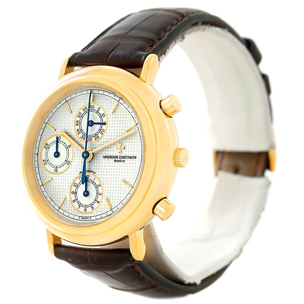 This image shows a Vacheron Constantin Vintage 47001 Men's Yellow Gold White Dial 47001 Men's Yellow Gold White Dial watch at a three-quarter angle, highlighting its gold case, chronograph dials, and brown leather strap.