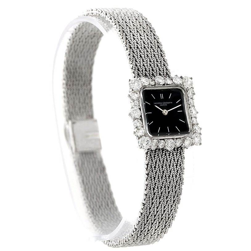 The image shows a Vacheron Constantin Vintage Women's White Gold Black Dial Women's White Gold Black Dial watch angled from the side, highlighting its woven band, black dial, and diamond-embedded bezel.