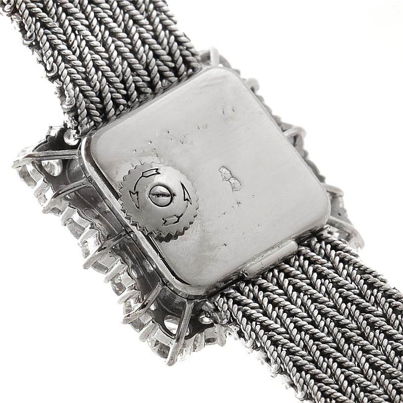 This close-up image shows the back of the case and part of the woven metal strap of a Vintage Vacheron Constantin watch.