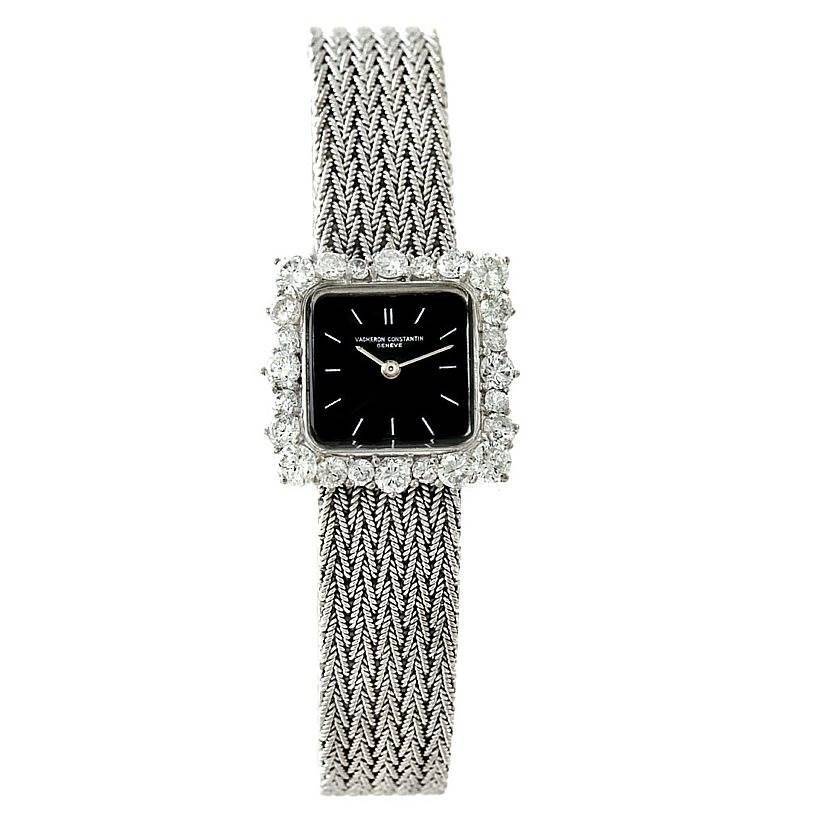 The image shows a front view of a vintage Vacheron Constantin watch, highlighting its black dial, diamond bezel, and metal woven strap.