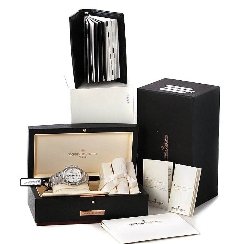 The image shows a Vacheron Constantin Overseas 49150 Men's Stainless Steel Silver Dial 49150 Men's Stainless Steel Silver Dial model watch in its open box, accompanied by booklets and additional watch accessories.