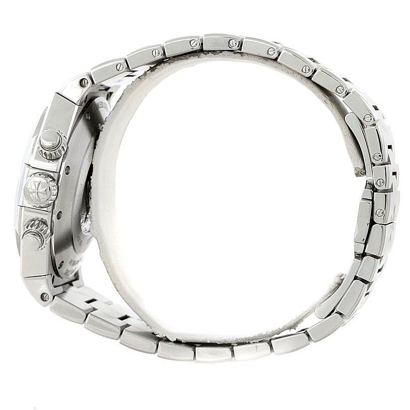 The image shows a side view of the Overseas model by Vacheron Constantin, highlighting the crown, pushers, and metal bracelet.