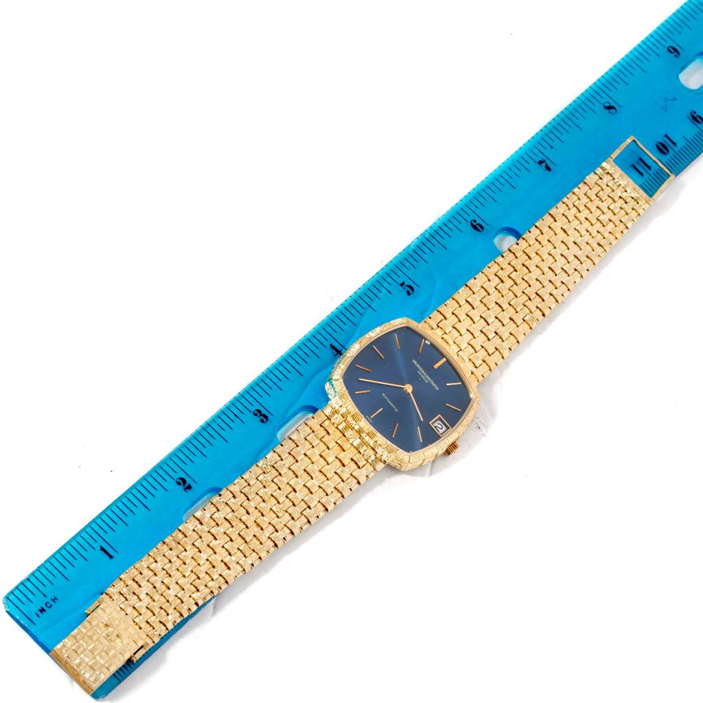 The image shows a Vacheron Constantin Vintage 7664 Men's Yellow Gold Blue Dial 7664 Men's Yellow Gold Blue Dial watch with a gold chain bracelet, placed next to a blue ruler for measurement.