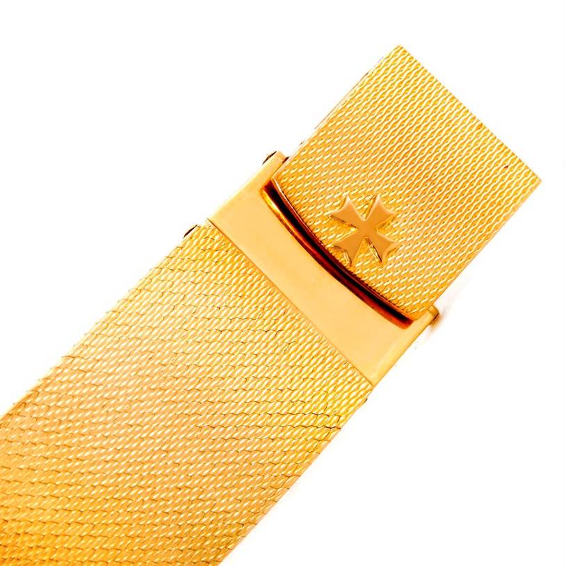 This image shows a close-up of the gold clasp and mesh band of a vintage Vacheron Constantin watch.