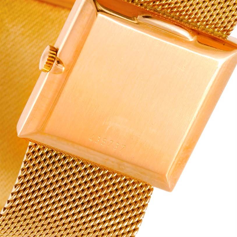 This image shows the back side and crown of a Vintage Vacheron Constantin watch along with its gold mesh strap.