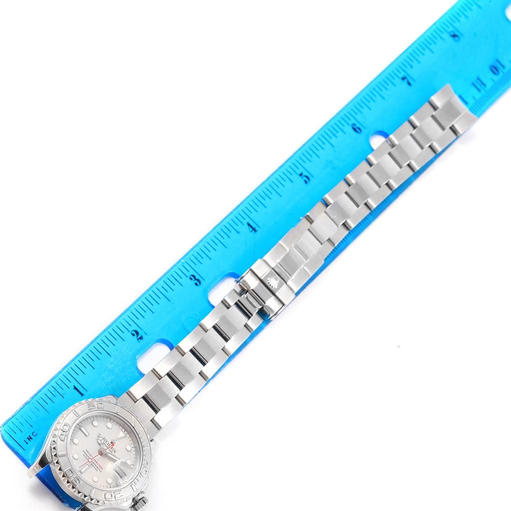 The image shows a Rolex Yacht-Master 169622 Women's Stainless Steel Silver Dial 169622 Women's Stainless Steel Silver Dial watch laid flat next to a blue ruler, displaying the entire watch and bracelet.