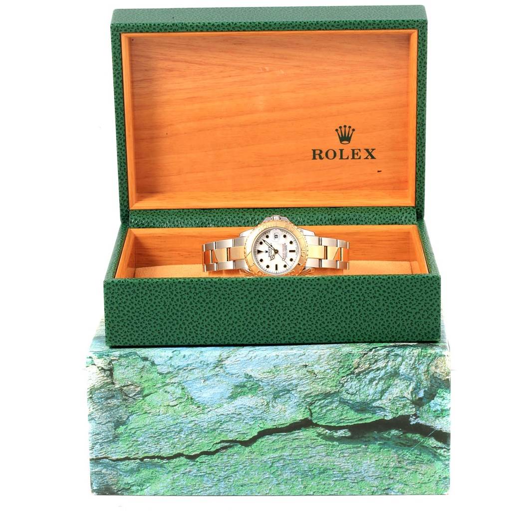 This image shows a Rolex Yacht-Master 169623 Women
s Steel and Gold (two tone) White Dial 169623 Women
s Steel and Gold (two tone) White Dial watch in an open green and wood-textured Rolex box, viewed from the front.