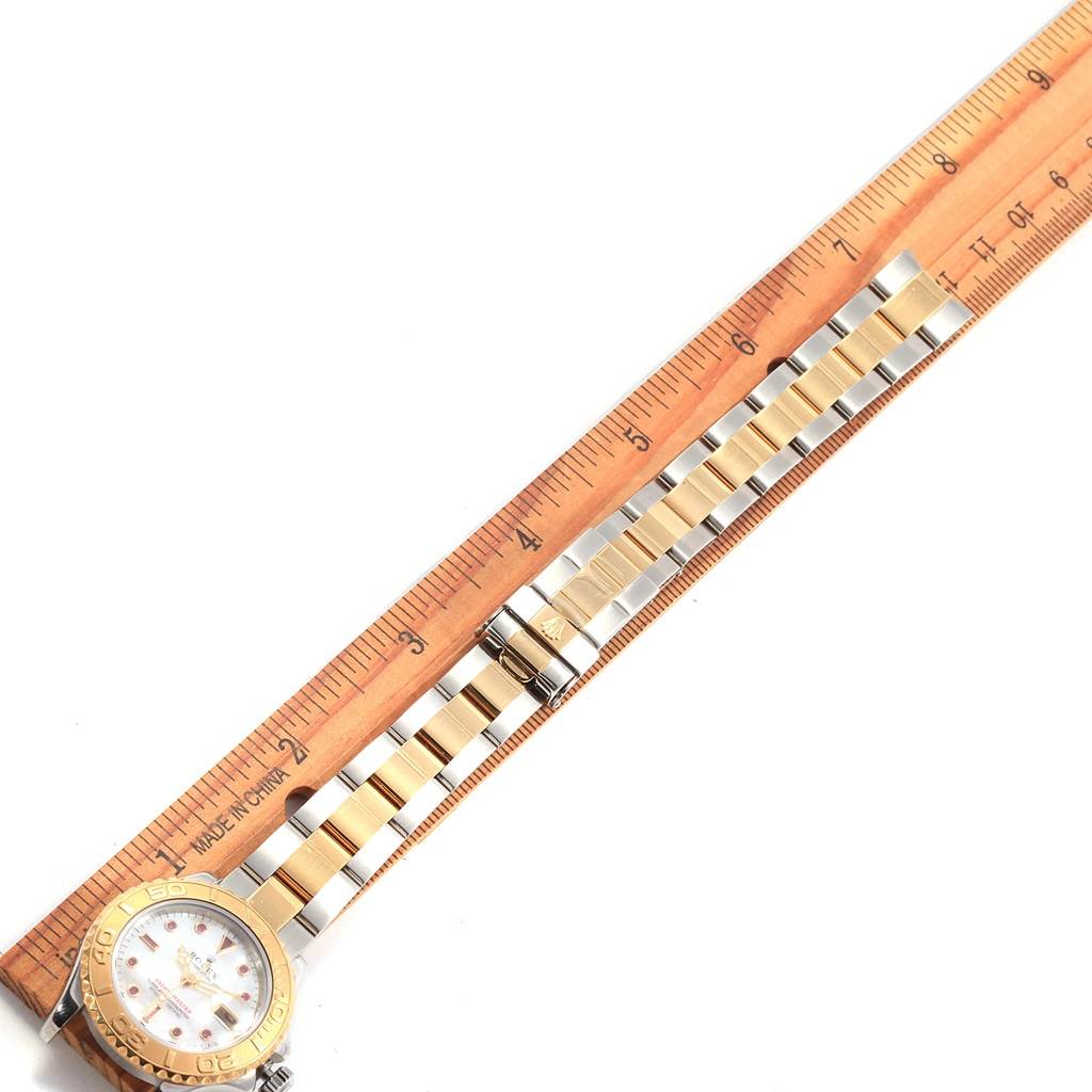 The image shows a Rolex Yacht-Master 169623 Women's Steel and Gold (two tone) Mother of Pearl Dial 169623 Women's Steel and Gold (two tone) Mother of Pearl Dial watch, with its band and clasp extended alongside a ruler for measurement.