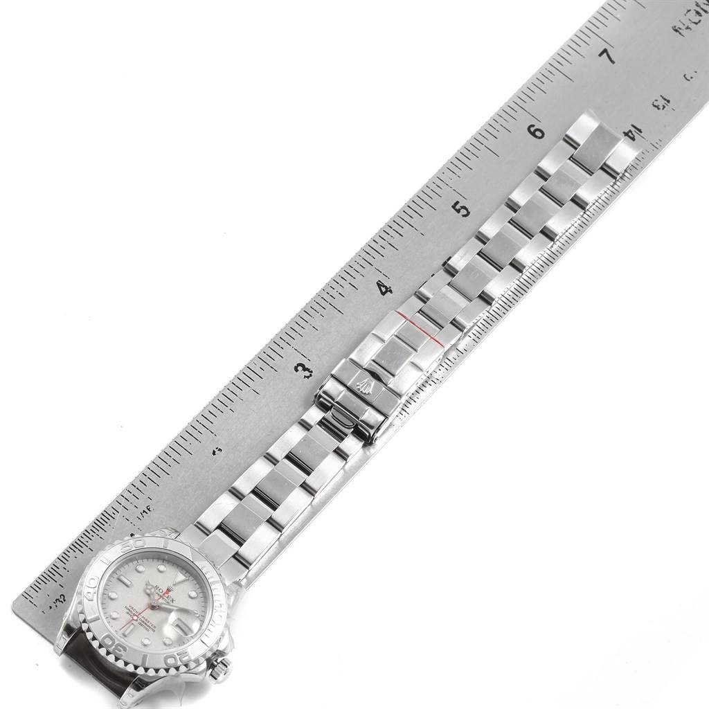 The Rolex Yacht-Master 169622 Women's Stainless Steel Silver Dial 169622 Women's Stainless Steel Silver Dial watch is shown from a top-down angle alongside a measuring ruler, displaying the watch face and bracelet.