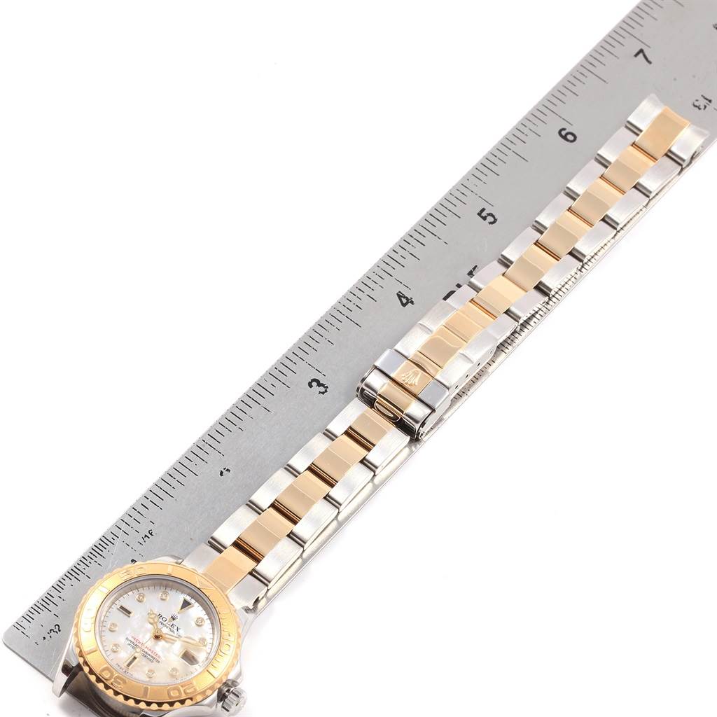 The image shows the Rolex Yacht-Master 169623 Women's Steel and Gold (two tone) Mother of Pearl Dial 169623 Women's Steel and Gold (two tone) Mother of Pearl Dial watch face and bracelet laid flat next to a measuring ruler.