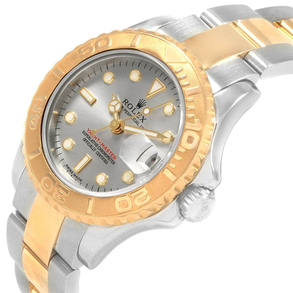 The image shows an angled close-up of a Rolex Yacht-Master 169623 Men
s Steel and Gold (two tone) Grey Dial 169623 Men
s Steel and Gold (two tone) Grey Dial, highlighting its gold bezel, crown, and part of the bracelet.