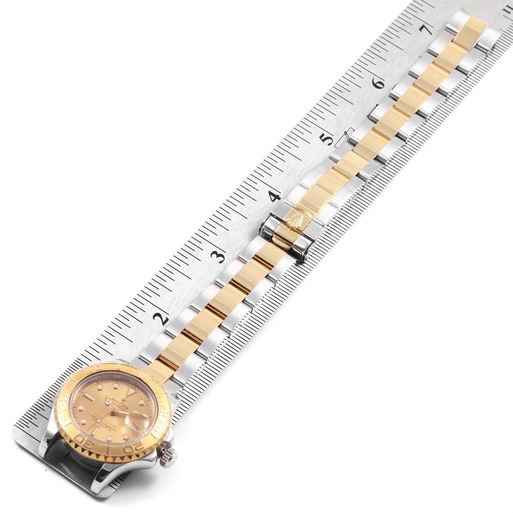 The Rolex Yacht-Master 69623 Women's Steel and Gold (two tone) Grey Dial 69623 Women's Steel and Gold (two tone) Grey Dial watch is shown from a top-down angle, displaying the face and metal band beside a ruler.