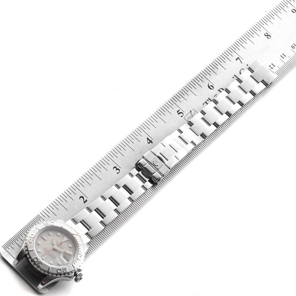 The Rolex Yacht-Master 169622 Women
s Stainless Steel Silver Dial 169622 Women
s Stainless Steel Silver Dial watch is shown laying flat with its bracelet and clasp extended, next to a ruler.