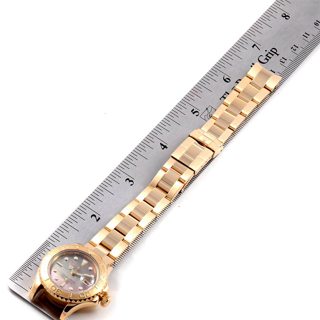 The image shows a Rolex Yacht-Master 169628 Women's Yellow Gold Mother of Pearl Dial 169628 Women's Yellow Gold Mother of Pearl Dial watch laid flat alongside a ruler, displaying the face and full length of the band.