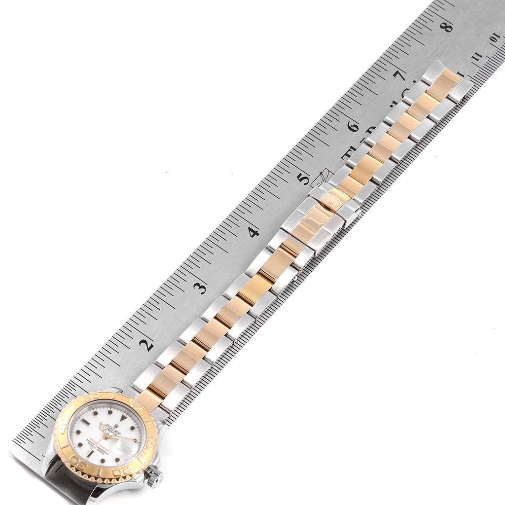 The Rolex Yacht-Master 169623 Steel and Gold (two tone) White Dial 169623 Steel and Gold (two tone) White Dial watch is shown from an overhead angle, featuring the face and bracelet next to a ruler for scale.