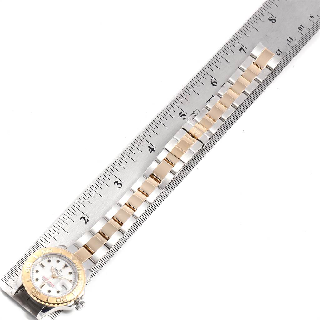 The angle shows the Rolex Yacht-Master 169623 Women's Steel and Gold (two tone) White Dial 169623 Women's Steel and Gold (two tone) White Dial watch's face and a portion of its bracelet, aligned next to a ruler.