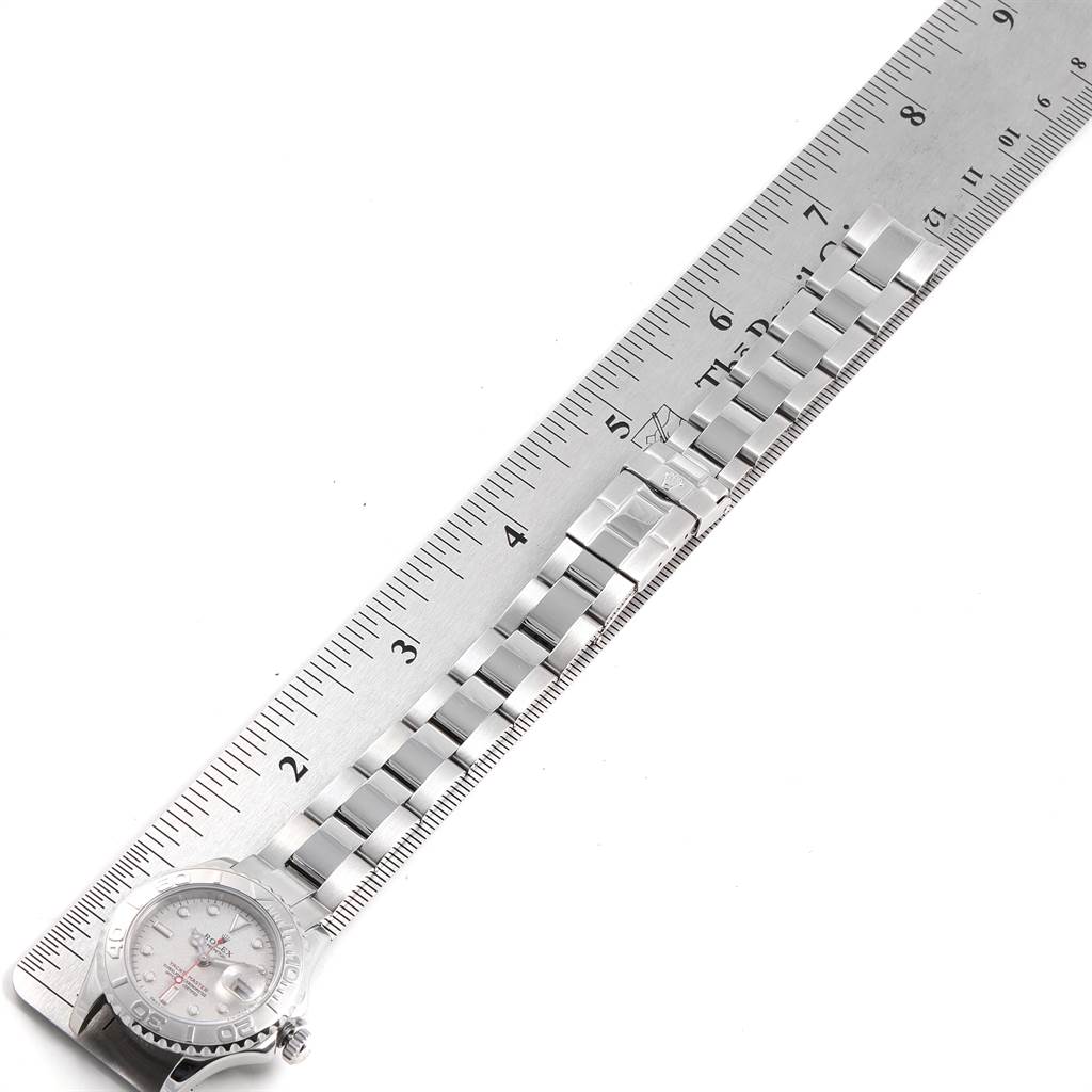 The Rolex Yacht-Master 169622 Women's Stainless Steel Silver Dial 169622 Women's Stainless Steel Silver Dial watch is positioned alongside a ruler, showing the face and part of the bracelet.