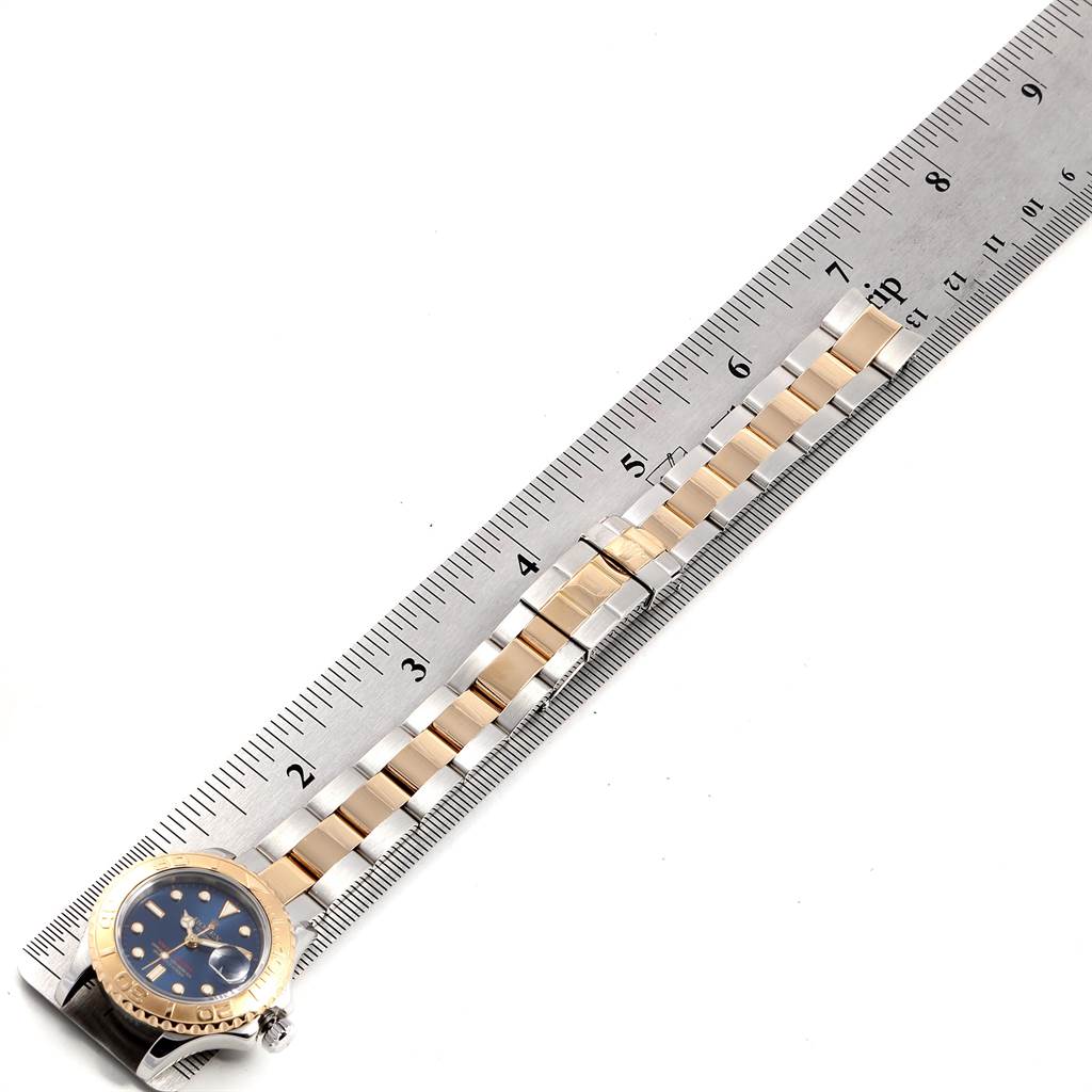 The Rolex Yacht-Master 69623 Women's Steel and Gold (two tone) Blue Dial 69623 Women's Steel and Gold (two tone) Blue Dial watch is shown at a slight angle, with its strap aligned with a ruler for measurement.
