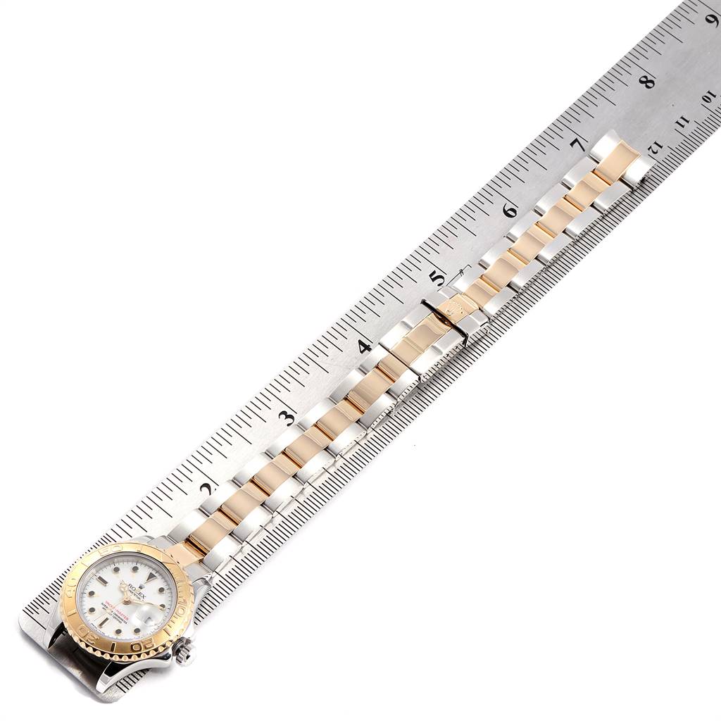 The image shows a horizontal view of a Rolex Yacht-Master 69623 Women's Steel and Gold (two tone) White Dial 69623 Women's Steel and Gold (two tone) White Dial watch with its bezel, dial, and bracelet measured against a ruler.