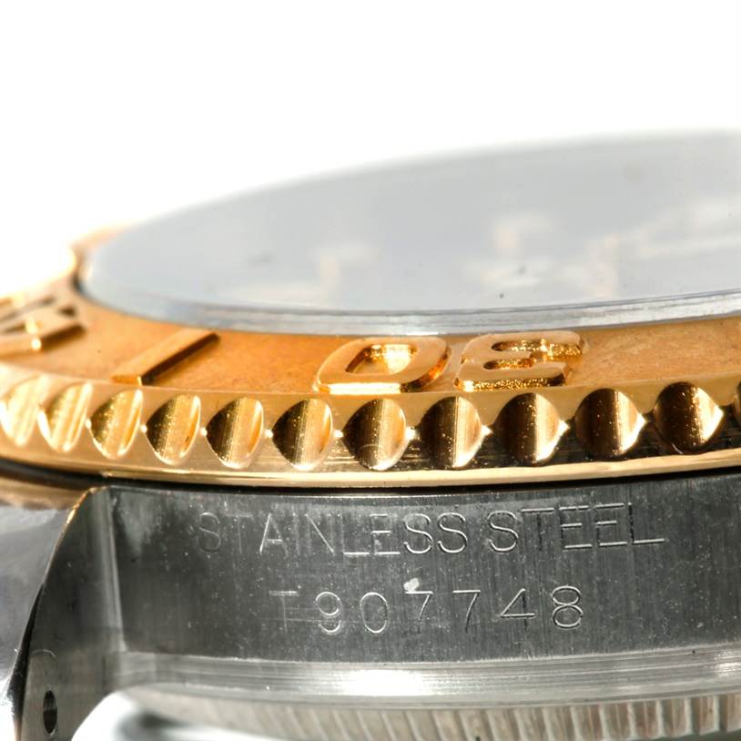 This close-up of the Rolex Yacht-Master 68623 Men's Stainless Steel Grey Dial 68623 Men's Stainless Steel Grey Dial watch displays the edge of the bezel and the side of the watch case, with visible engraving.