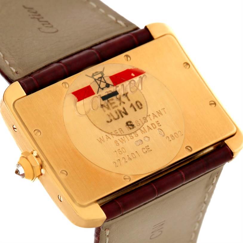 The image shows the back case of a Cartier Tank Divan WA301170? Men's Yellow Gold Silver Dial WA301170? Men's Yellow Gold Silver Dial watch at an angle, highlighting the inscriptions and leather strap.