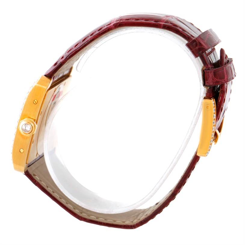 This image shows a side view of the Tank Divan model by Cartier, highlighting its gold casing and burgundy leather strap.