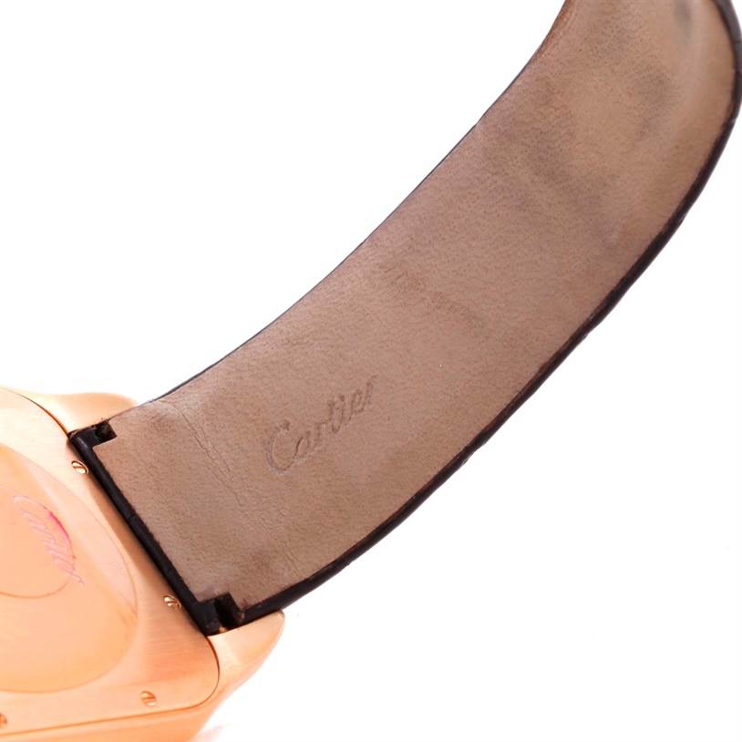 This image shows the strap and a portion of the back case of the Santos Dumont watch by Cartier, featuring the engraved Cartier logo.